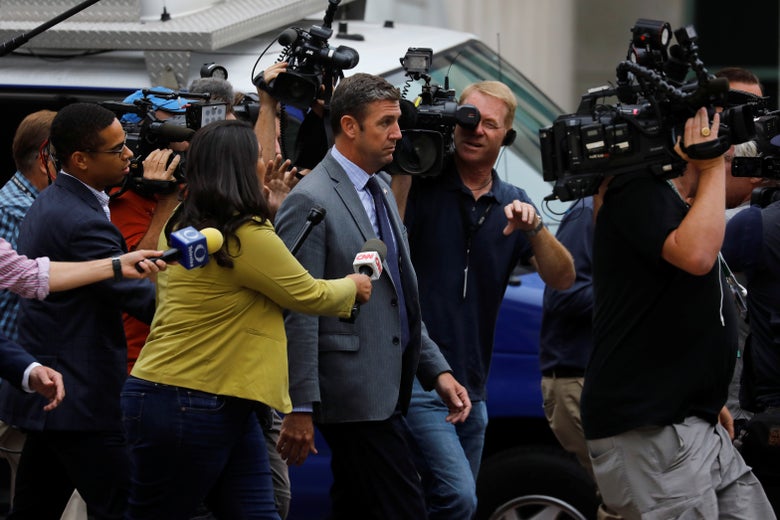 Hunter walks while being surrounded by a crowd of reporters.